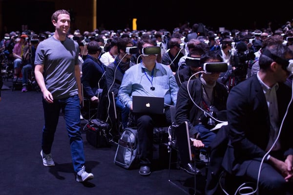 Mark Zuckerberg walking through an audience wearing VR goggles