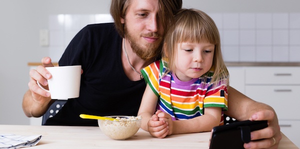 Father and daughter watching video on mobile phone